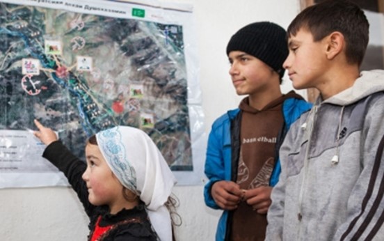 This is an image from a Mercy Corps school safety program in Tajikistan showing a young girl highlighting on a map areas of risk in her community.